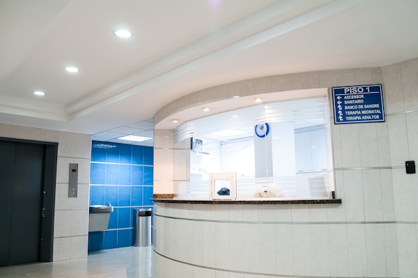 A hospital corridor with overhead lighting.